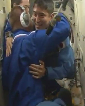 入室直後、滞在中のクルーと抱き合う大西さん 入室直後、滞在中のクルーと抱き合う大西さん