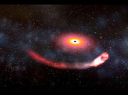 （引き伸ばされる中性子星とそれを飲み込むブラックホールの想像図）