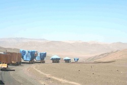 砂漠の中、隊列を組んで進むトラック