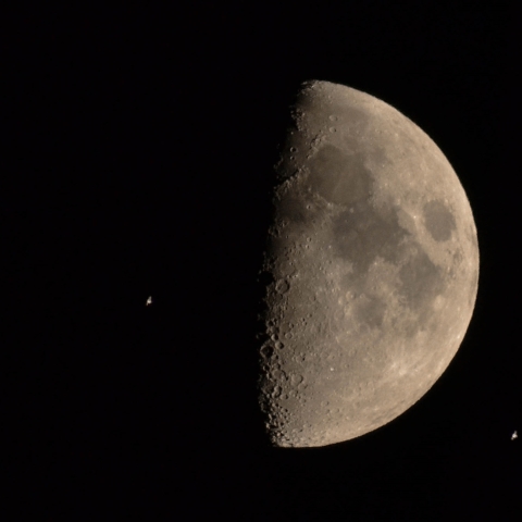 上弦の月を横切る国際宇宙ステーション