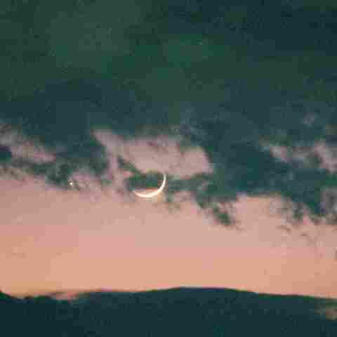 雪雲の間に輝く月と水星