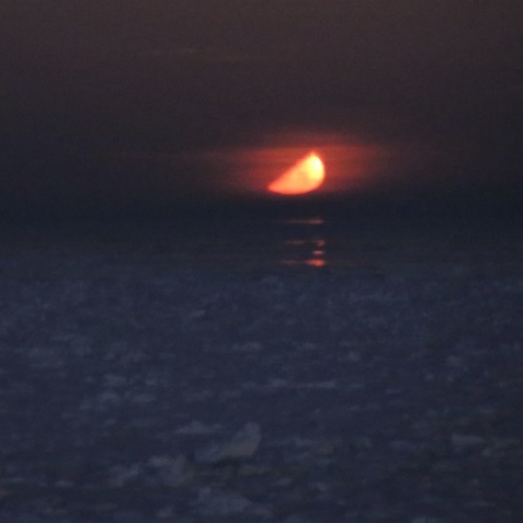 流氷原に沈む上弦の月