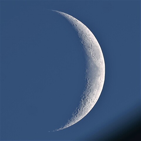 屋上に隠れそうな月