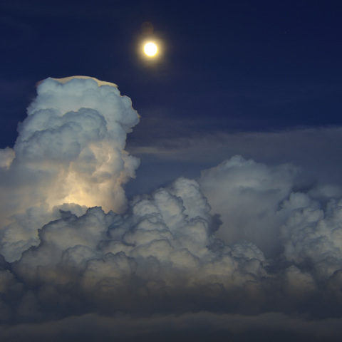 光る積乱雲に照らす月