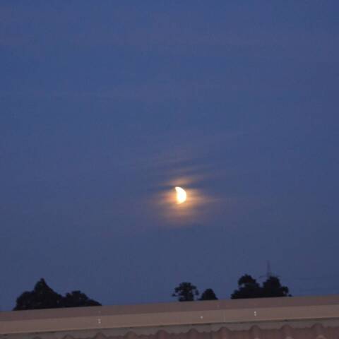 昇る満月が半月に