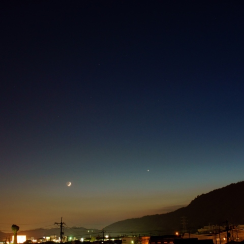 市街地の上に見えた地球照をまとった月と金星