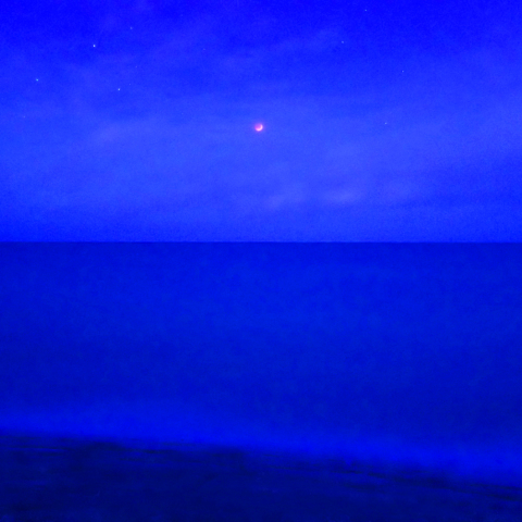 南国の海に浮かぶ赤い月