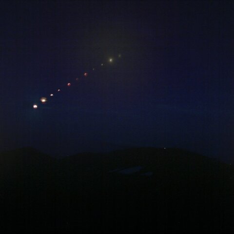 残雪の蔵王の山々にかかる赤い月