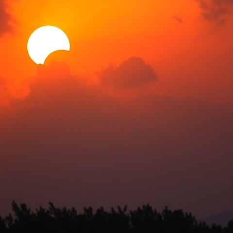 薩摩半島南方に沈み行く欠けた太陽