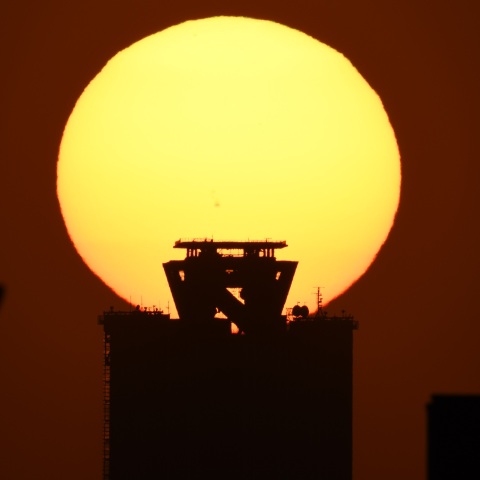 大阪府咲洲庁舎ビルへの日没 (2025/04/07)