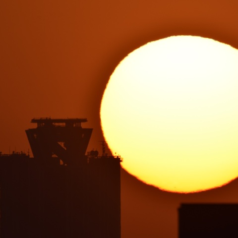 大阪府咲洲庁舎ビルへの日没 (2022/04/08)