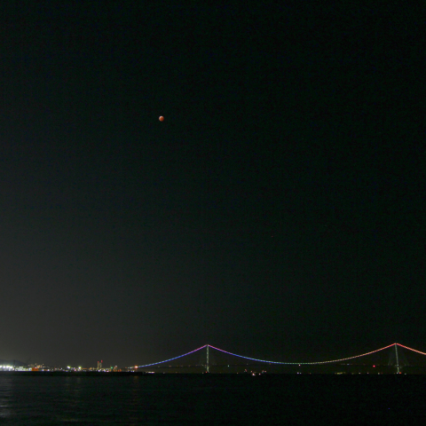 皆既中の月とレインボーカラーの明石大橋